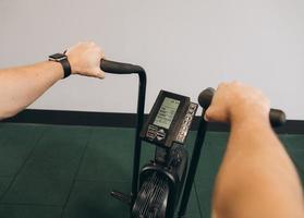 hombre usando bicicleta de aire para entrenamiento cardiovascular en el gimnasio de entrenamiento cruzado. foto