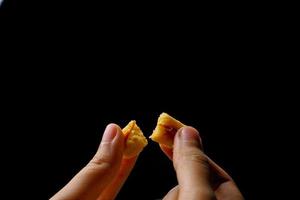 crujientes galletas kaastengels. galletas indonesias de influencia holandesa, típicamente servidas durante hari raya eid fitri. imagen de enfoque selectivo sobre fondo negro foto