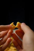 crujientes galletas kaastengels. galletas indonesias de influencia holandesa, típicamente servidas durante hari raya eid fitri. imagen de enfoque selectivo sobre fondo negro foto