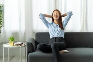 Happy asian woman Relaxing Sitting On Sofa At Home, work from home concept. photo