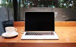 Laptop and cup coffe on the table photo