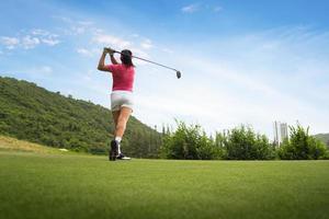 Mujeres jóvenes jugadoras de golf tiro de swing en el campo en el amanecer de la mañana foto