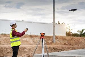 Engineer surveyor working with theodolite at construction site photo