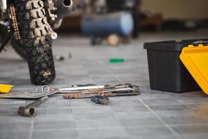 Repairing and maintenance concepts, Worktools on floor for repairing motorcycle in workshop garage photo