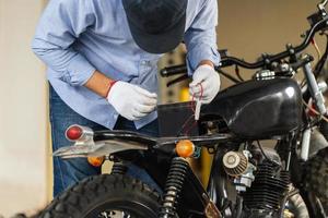 Man repairing motorcycle in repair shop, Mechanic fixing motorbike in workshop garage, Repairing and maintenance concepts photo