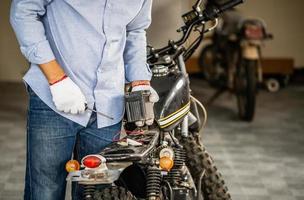 Man repairing motorcycle in repair shop, Mechanic fixing motorbike in workshop garage, Repairing and maintenance concepts photo