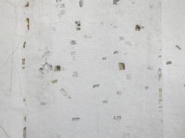 Old white cement wall with traces of masking tape from pasting the poster. photo