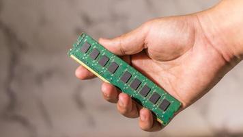 Close up male hand holding a ddr3 computer ram on abstack white background photo