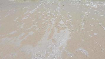 ralenti de la ligne de mousse d'eau de mer se déplaçant vers le fond de la plage de sable - fond de la nature de l'eau de mer video