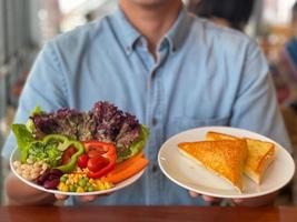 Man hands holding a green salad. Healthy lifestyle and vegetarian vegan, Intermittent Fasting concept. photo