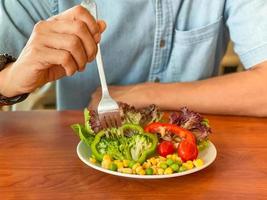 Man hands holding a green salad. Healthy lifestyle and vegetarian vegan, Intermittent Fasting concept. photo