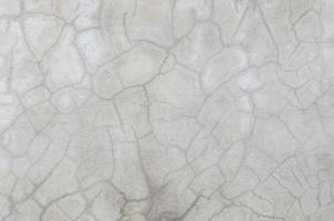 abstract of cement cracked texture on old white masonry wall photo