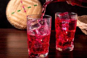 Red flavored nectar drink on a wooden background photo