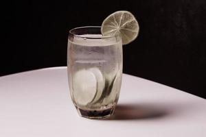 jugo de limón en un vaso transparente con lima decorativa