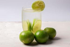 jugo de limón en un vaso transparente con lima decorativa foto