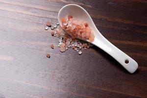 Himalayan salt in a white spoon photo