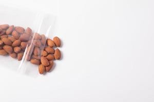 Almonds in plastic bags on a white background photo