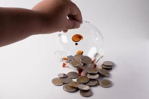 Hands are putting coins in a piggy bank. Money saving concept photo