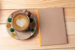Coffee mugs and notebooks on wooden background