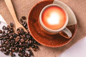 granos de café robusta y tazas de café de cerámica marrón foto