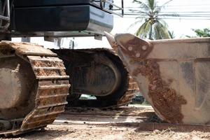 Close-up of a large  Dirty rear wheel of an excavator. Construction machinery. Detail of heavy tractor wheel photo