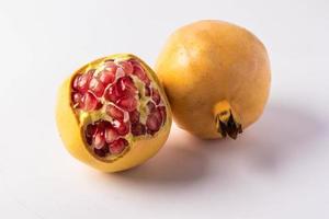 Yellow pomegranate on a white background photo