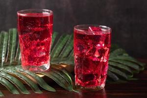 Red flavored nectar drink on a wooden background photo