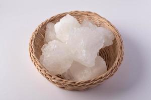 Rock sugar in a wicker basket on a white background photo