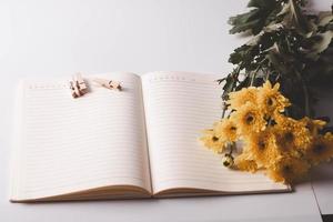 Coffee mugs, paper clips and yellow flowers. On a white background Copy space. photo