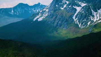 Aerial Over Valley With Snow Capped Mountains In Distance video