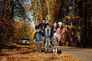 National holiday of United Kingdom. Large family with four kids holding british flags in autumn park.  Britishness celebrating UK. photo