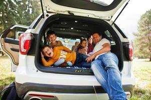 niños de familia en el interior del vehículo. niños en el baúl. viajar en coche por las montañas, concepto de ambiente. padres felices foto