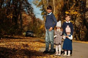 cuatro niños posando en el parque de otoño. foto