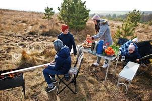 Family barbecuing on a deck in the pine forest. Bbq day with grill. photo