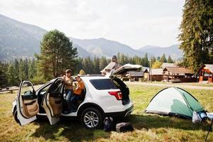 Two brothers eat apples at vehicle interior. Traveling by car in the mountains, atmosphere concept. photo