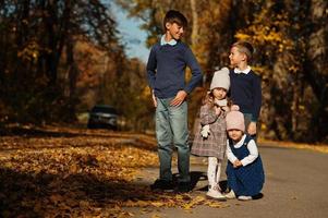 cuatro niños posando en el parque de otoño. foto