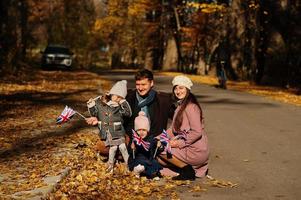 National holiday of United Kingdom. Family with british flags in autumn park.  Britishness celebrating UK. Two kids. photo