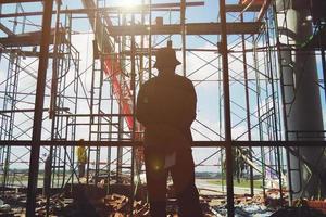 Worker man standing at the construction site photo