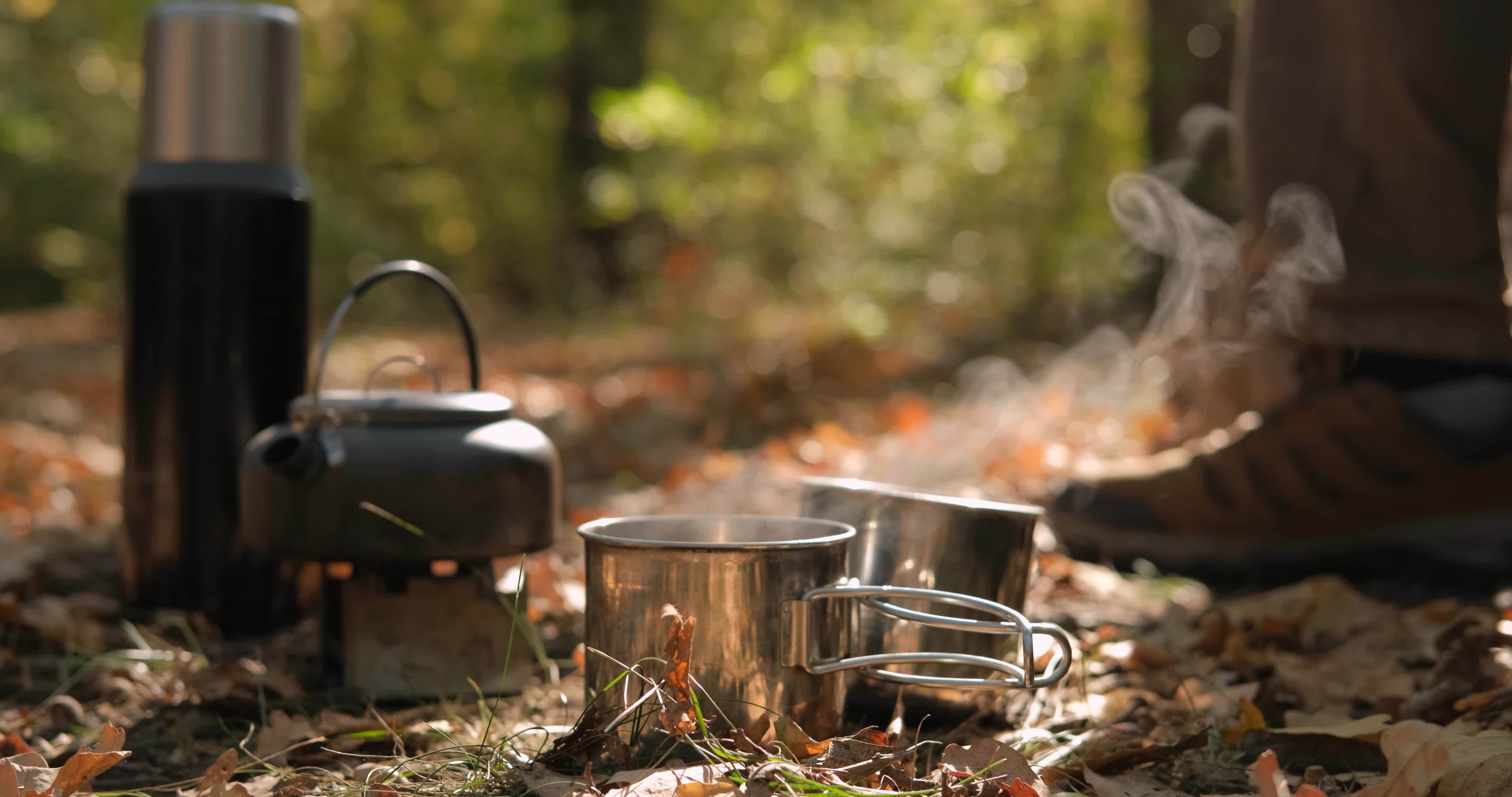 Close up of solid fuel stove with water kettle on fire, tea or coffee prepearing outdoors