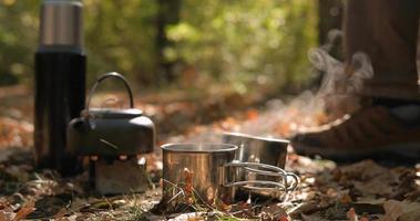 cierre de una estufa de combustible sólido con hervidor de agua en llamas, preparación de té o café al aire libre