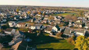 Volando a un pequeño pueblo en Illinois en otoño. hermoso otoño, hojas caídas cerca de las casas. hermosos terrenos casas y calles en america. video