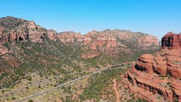 Breathtaken overlook of Red Rock scenic byway, Sedona Arizona. Aerial drone view of unique natural landscape of red rocks with narrow roads along area in summer, copy space. Concept of landscape video