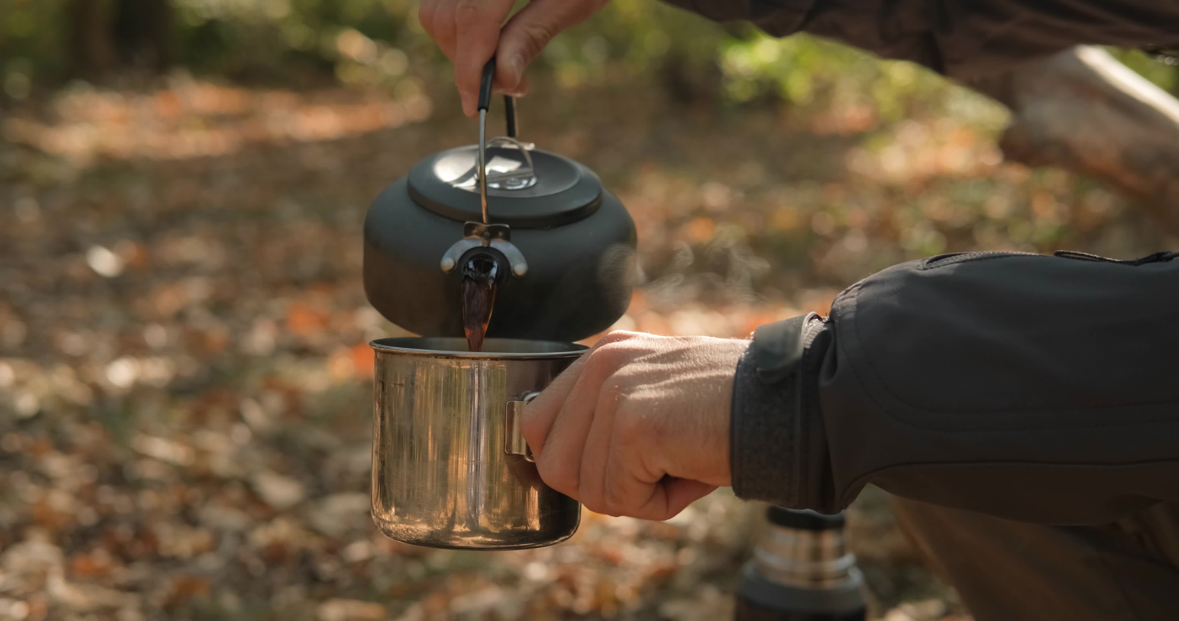 Close up of solid fuel stove with water kettle on fire, tea or coffee