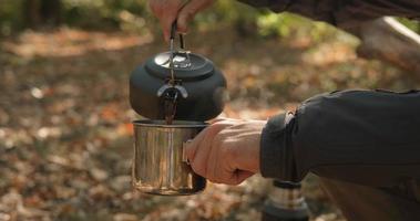 Nahaufnahme eines Festbrennstoffofens mit Wasserkocher in Brand, Tee oder Kaffee, der im Freien zubereitet wird video