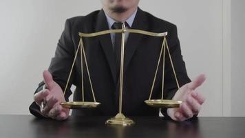 justice and law concept.Male lawyer in the office with brass scale on wooden table video