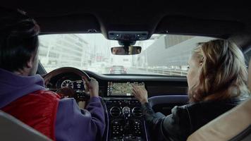 A man drives a Bentley while a woman looks at a map, a trip in the city video