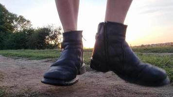 tanzende männliche beine in alten schuhen in der natur und sonnenuntergang im sommer. video