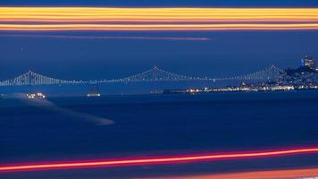 puente de la bahía en la distancia con semáforos de larga exposición en primer plano foto