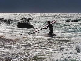 Surfer running in waves at shore. - bright photo