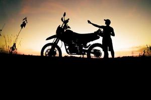 Men's silhouettes and touring motocross bikes. Park to relax in the mountains in the evening. adventure travel and leisure concept photo